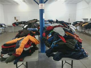 tables covered with heaps of Donated Winter Coats